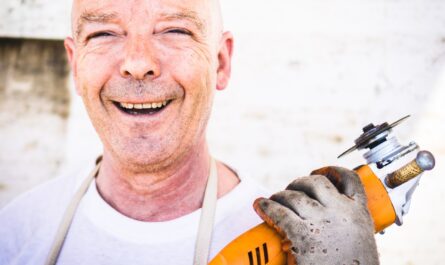 man holding orange angle grinder