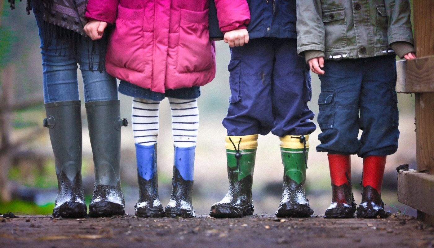 four children standing on dirt during daytime
